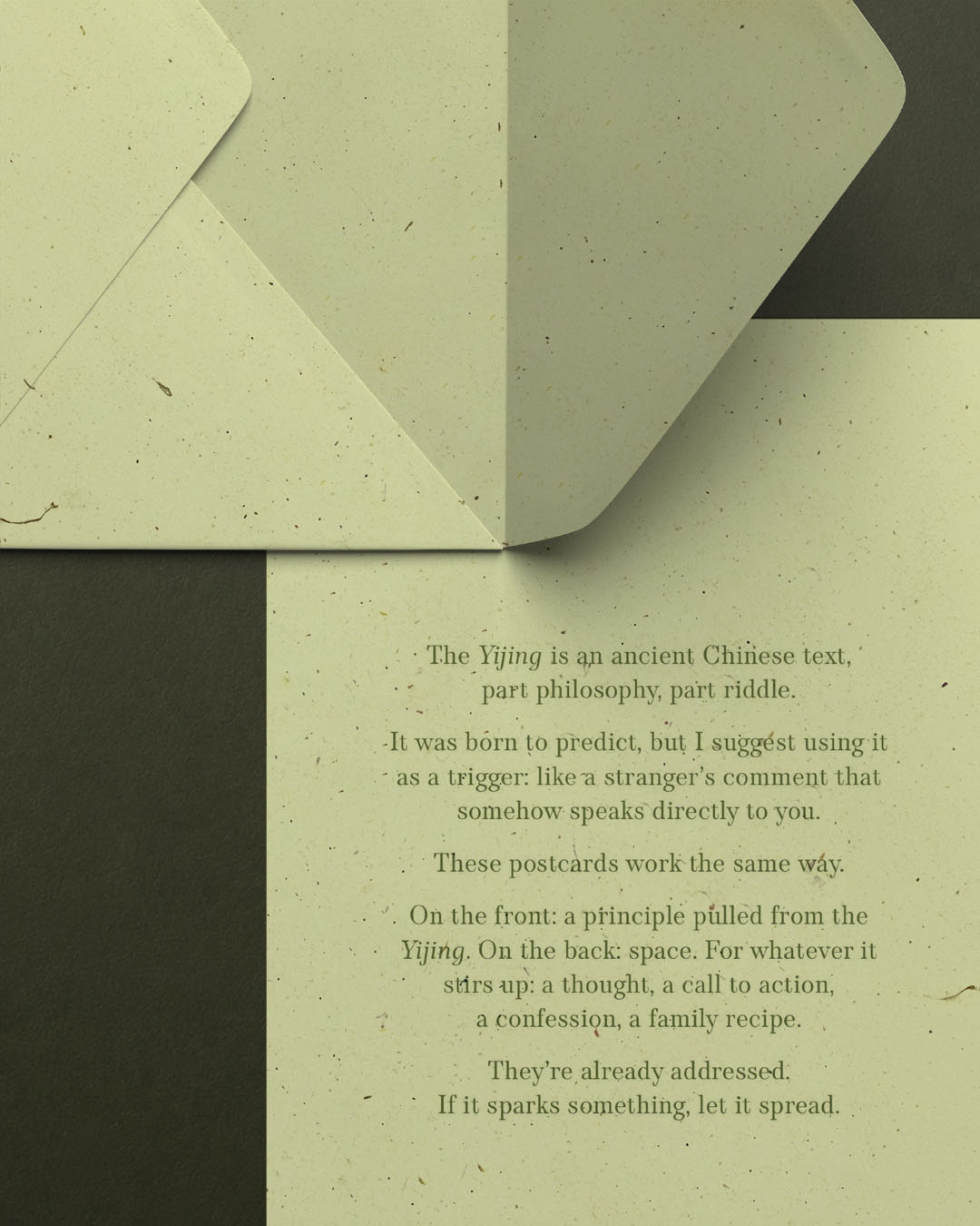 Two open olive-paper envelopes overlap a printed sheet bearing the project manifesto: 'The Yijing is an ancient Chinese text, part philosophy, part riddle. It was born to predict, but I suggest using it as a trigger: like a stranger's comment that somehow speaks directly to you. These postcards work the same way. On the front: a principle pulled from the Yijing. On the back: space. For whatever it stirs up: a thought, a call to action, a confession, a family recipe. They're already addressed. If it sparks something, let it spread.'